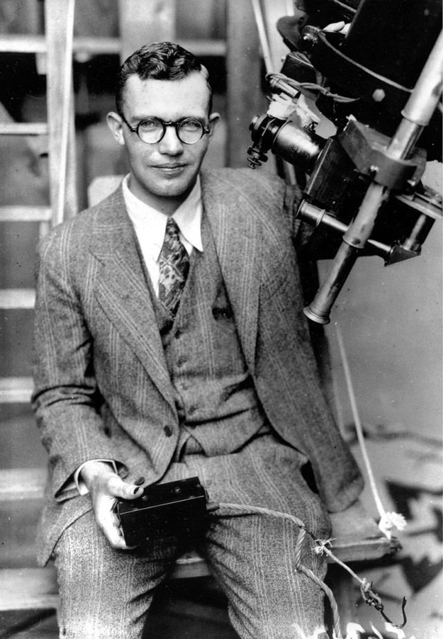 In this 1931 file photo, Clyde Tombaugh poses with the telescope through which he discovered the Pluto at the Lowell Observatory on Observatory Hill in Flagstaff, Ariz. On Tuesday, July 14, 2015, NASA's New Horizons spacecraft, carrying a small canister with his ashes, is scheduled to pass within 7,800 miles of Pluto which he discovered 85 years ago. (AP)