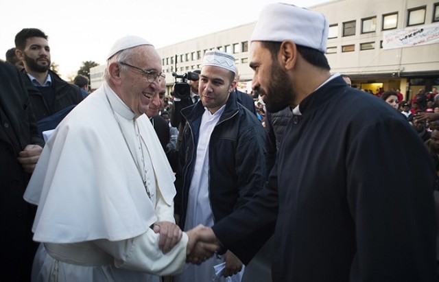 Pope Francis shakes hands with Muslims faithful during his visit at the Castelnuovo di Porto refugees center, some 30km (18, 6 miles) from Rome, Thursday, March 24, 2016. The pontiff washed and kissed the feet of Muslim, Orthodox, Hindu and Catholic refugees Thursday, declaring them children of the same God, in a gesture of welcome and brotherhood at a time when anti-Muslim and anti-immigrant sentiment has spiked following the Brussels attacks. (L'Osservatore Romano/Pool Photo via AP)