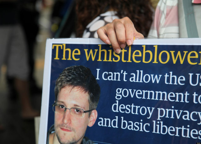 A protester holds a placard during a rally in support of Edward Snowden, the former National Security Agency contractor, in Hong Kong, China, on Saturday, June 15, 2013. Protesters marched to Hong Kongs government headquarters demanding their leaders protect Edward Snowden, who fled to the city after exposing a U.S. surveillance program. Photographer: Luke Casey/Bloomberg via Getty Images