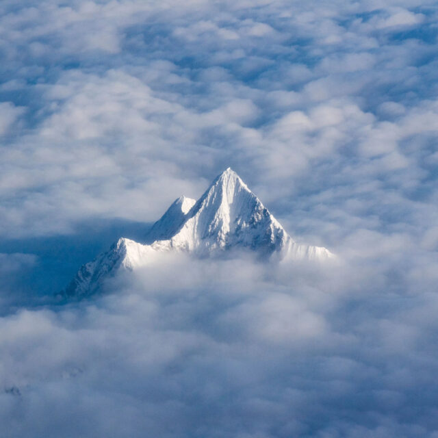 The Himalayas peeping through clouds. This photograph of the mountains won many awards